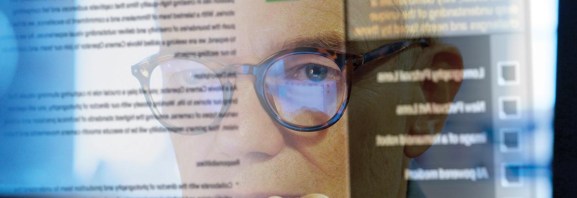 Photo of a man looking at a computer screen with words on it