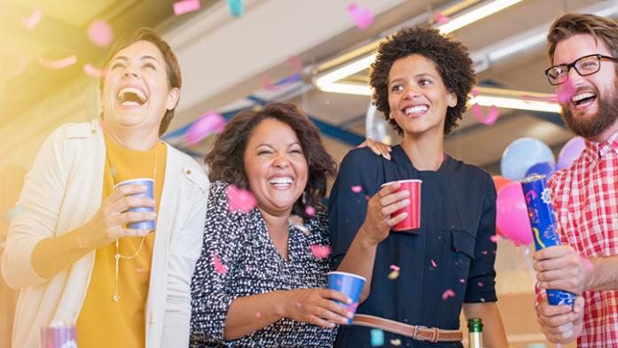 Group of coworkers laughing and enjoying a party