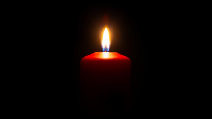 small red candle lit with a black background
