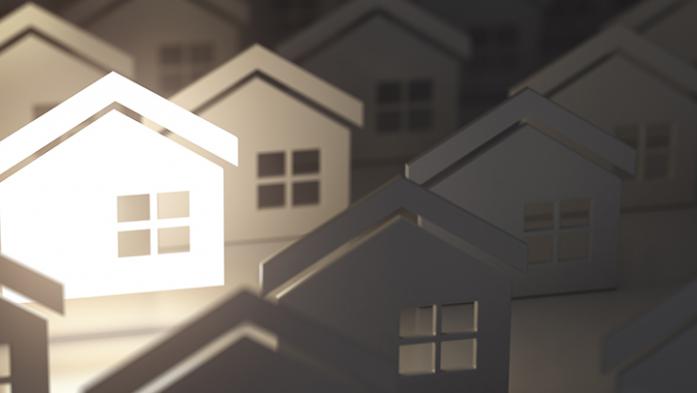 illustration of many house cutouts with one illuminated in white