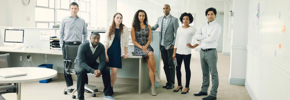 people standing and sitting in an office