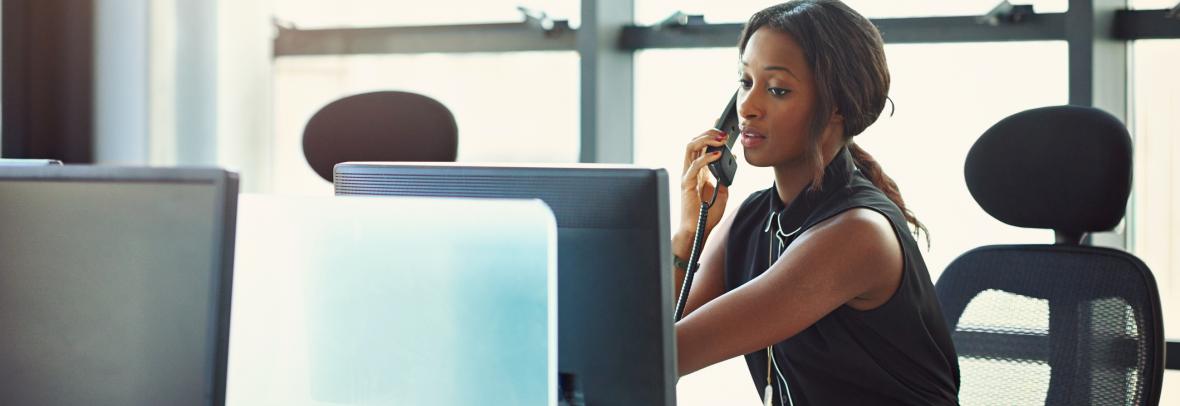 woman at computer using telephone