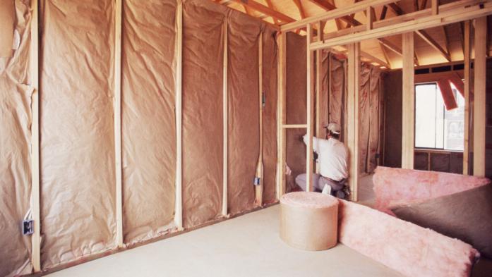 Installing insulation into wall of new home